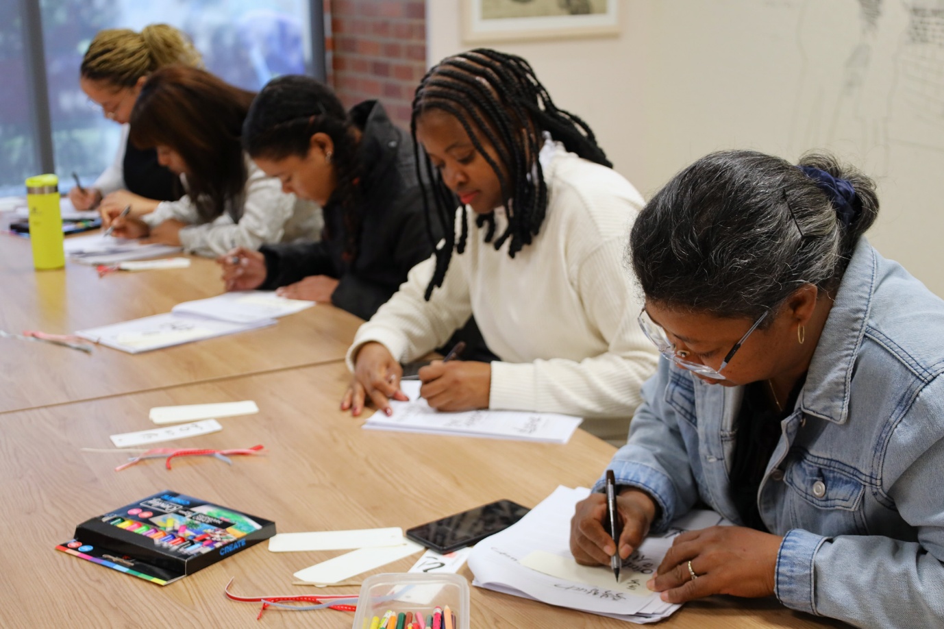 A group of people writing on papers

AI-generated content may be incorrect.