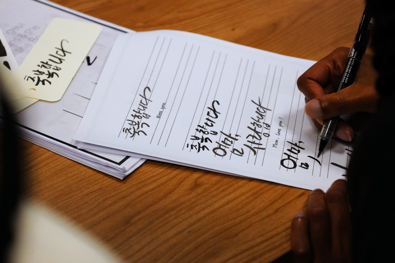 A person writing on a piece of paper

AI-generated content may be incorrect.