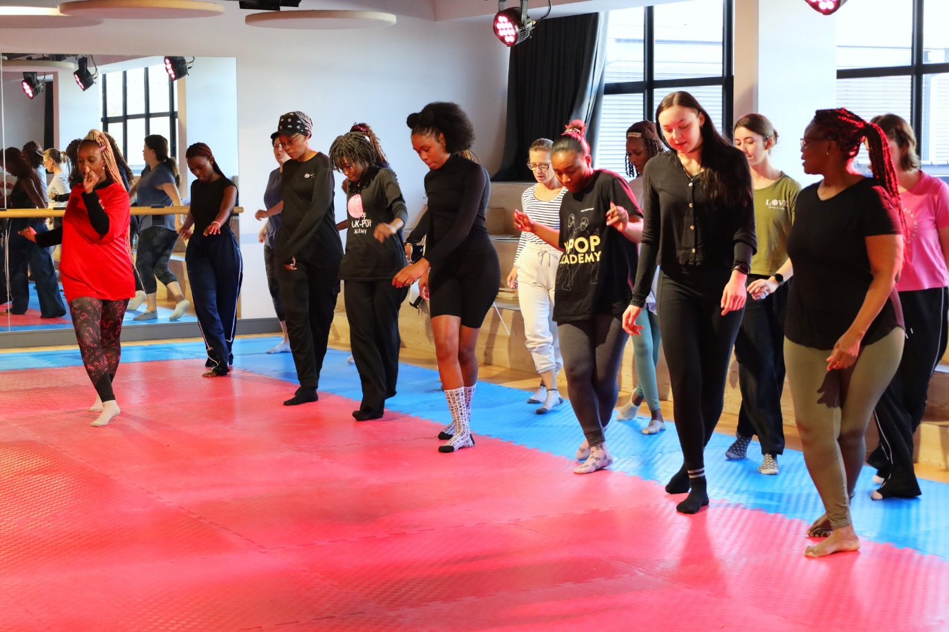 A group of women dancing in a room

AI-generated content may be incorrect.