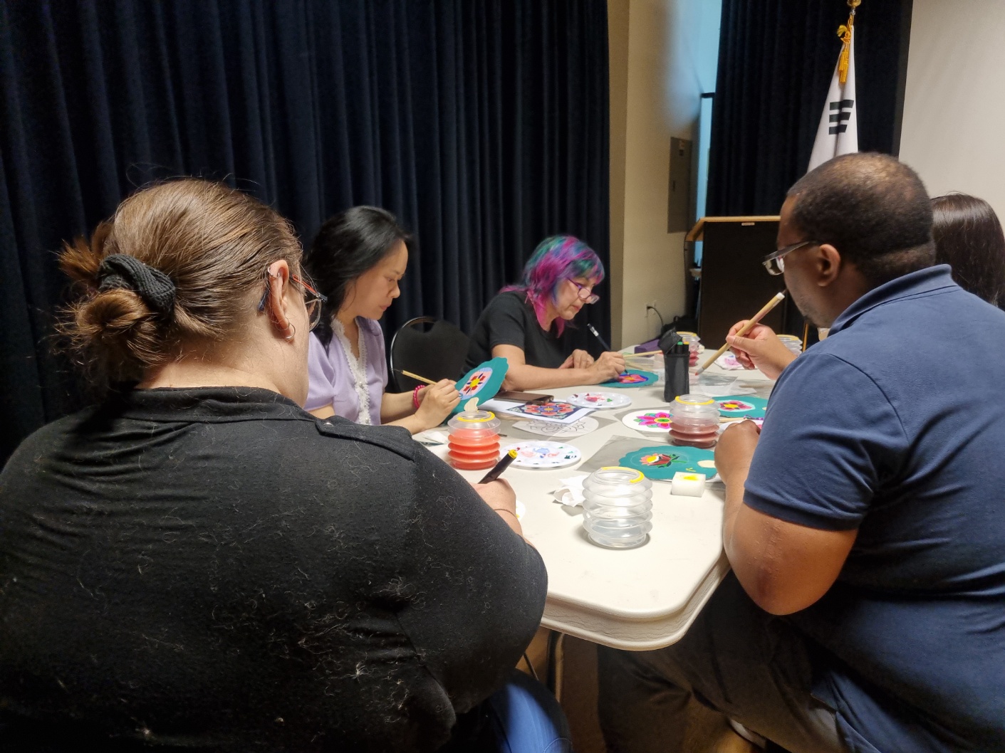 Participants painting Dancheong patterns on fans