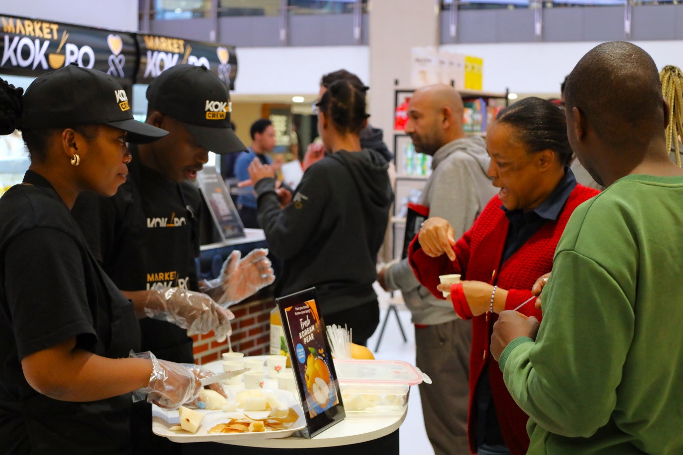 A group of people standing around a table

AI-generated content may be incorrect.