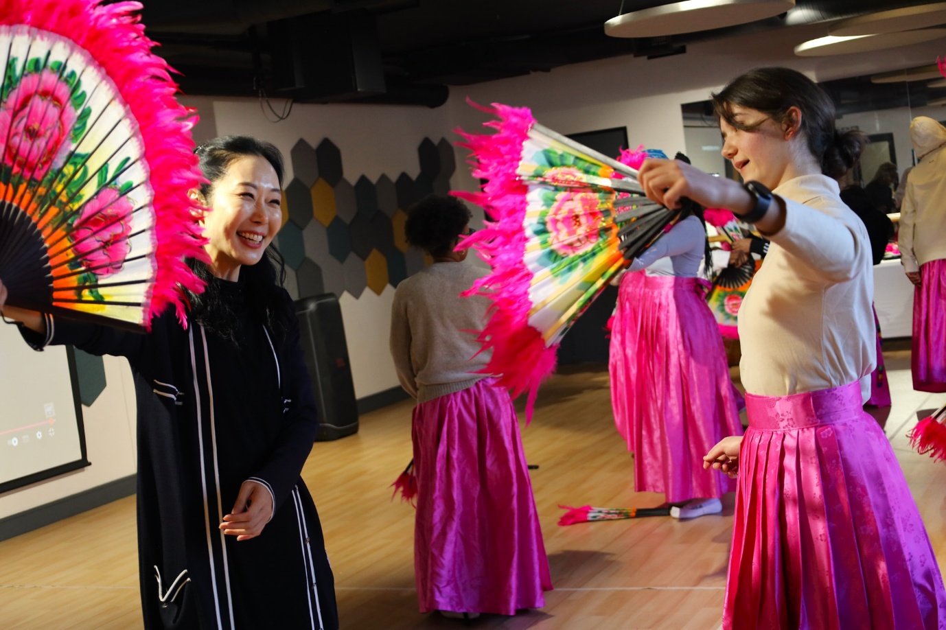 A group of women in pink skirts

AI-generated content may be incorrect.