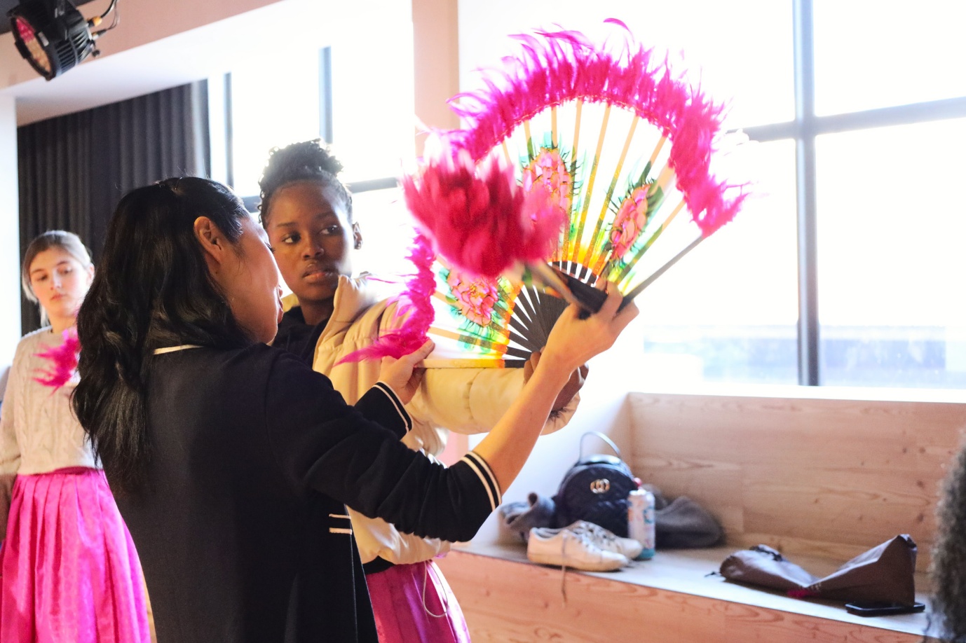 A group of women holding a fan

AI-generated content may be incorrect.