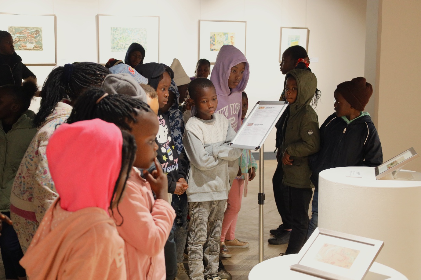 A group of children standing in a room

AI-generated content may be incorrect.
