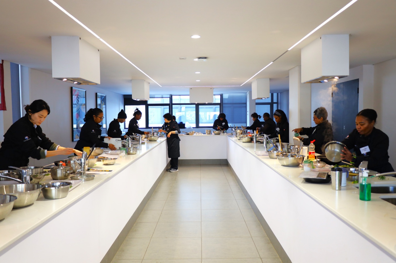 A group of people in a kitchen

AI-generated content may be incorrect.