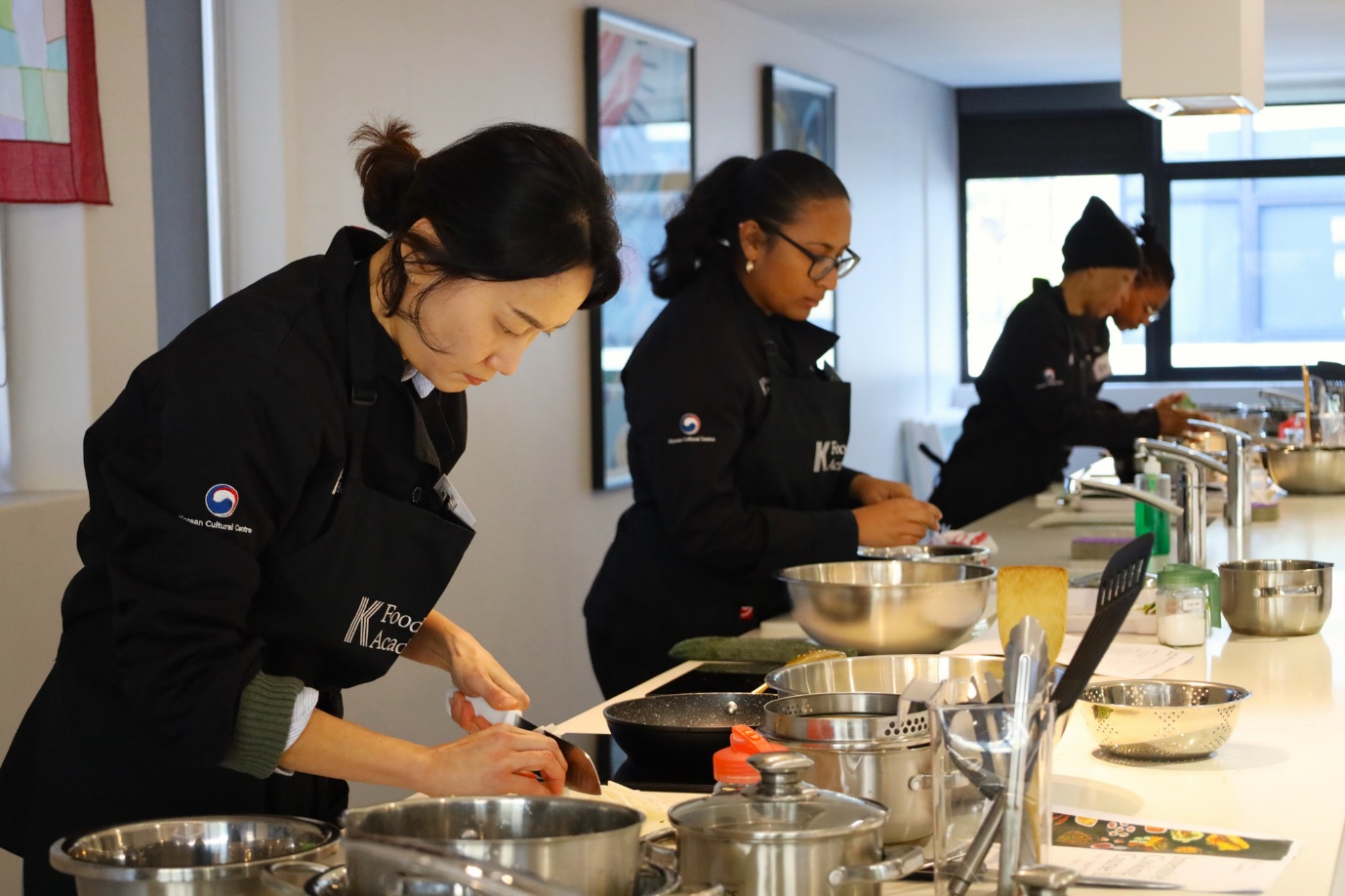 A group of women cooking in a kitchen

AI-generated content may be incorrect.