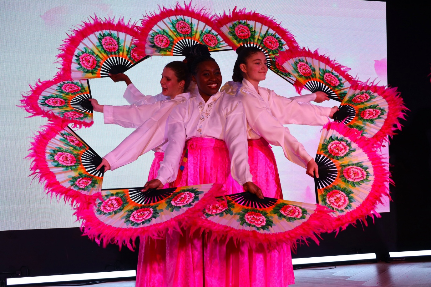 A group of women holding fans

AI-generated content may be incorrect.