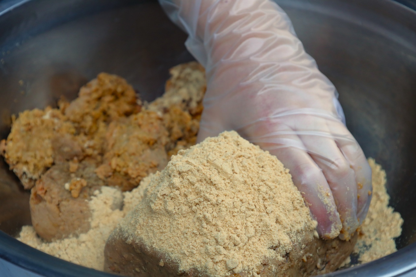 A person's hand in gloves mixing food in a bowl

AI-generated content may be incorrect.