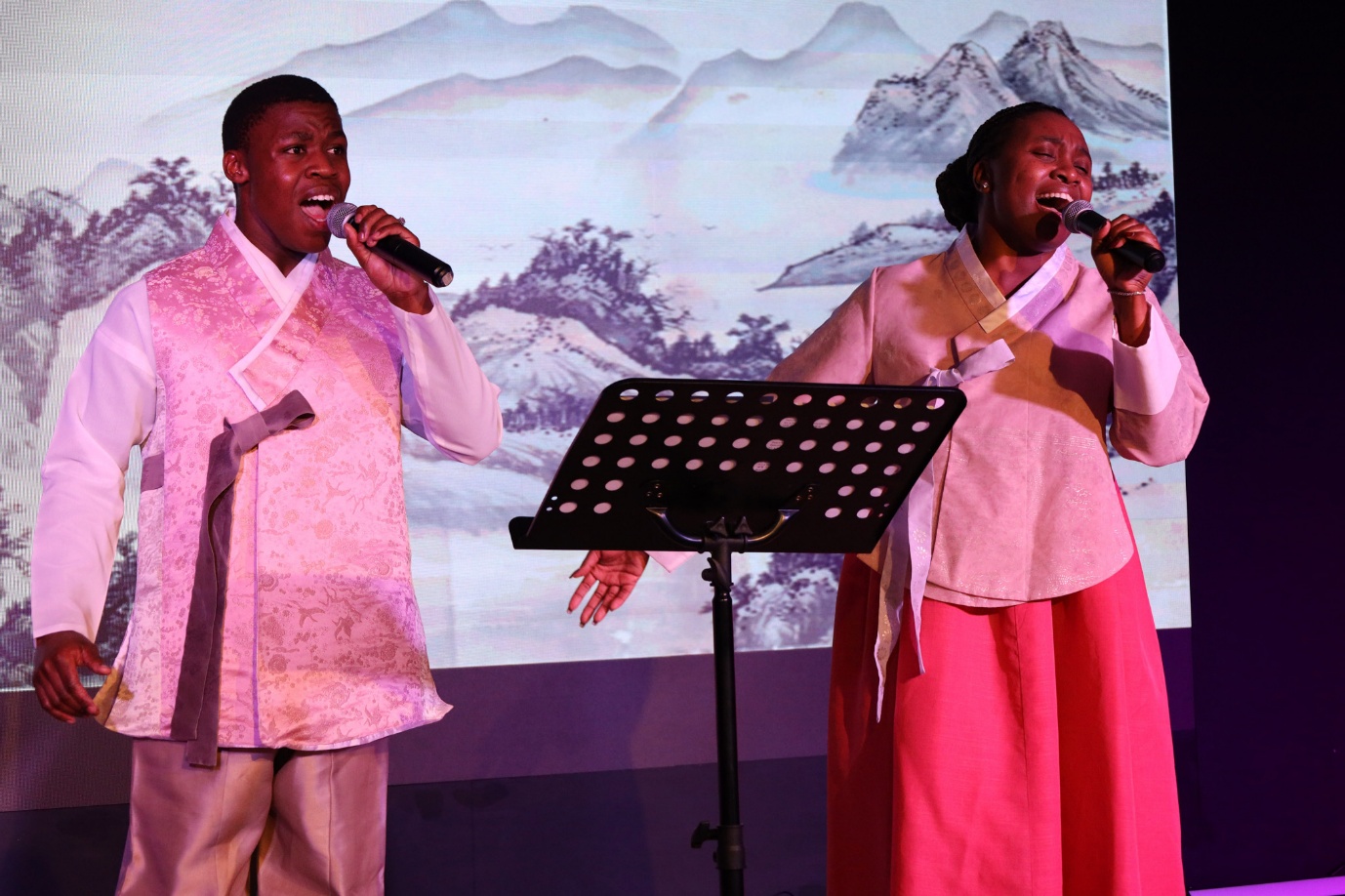 A group of people singing on stage

AI-generated content may be incorrect.