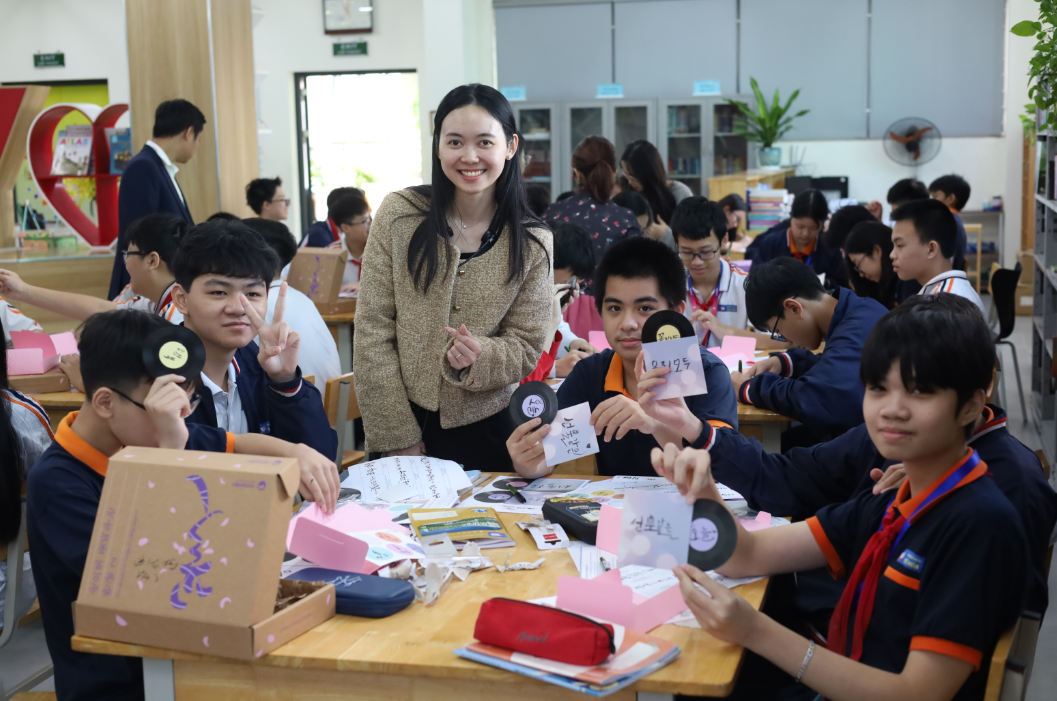옌화 중학교 선생님과 학생들이 만든 작품과 사진을 찍는다