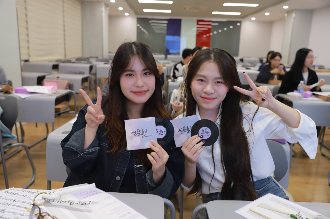 한국탐구동아리(KDC)&nbsp;소속&nbsp;대학생 2명은 만든 작품과 사진을 찍는다.